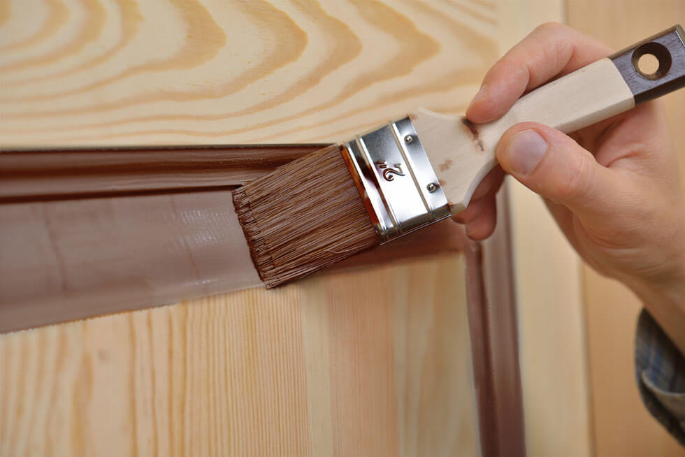 Maler lackiert eine Holztür